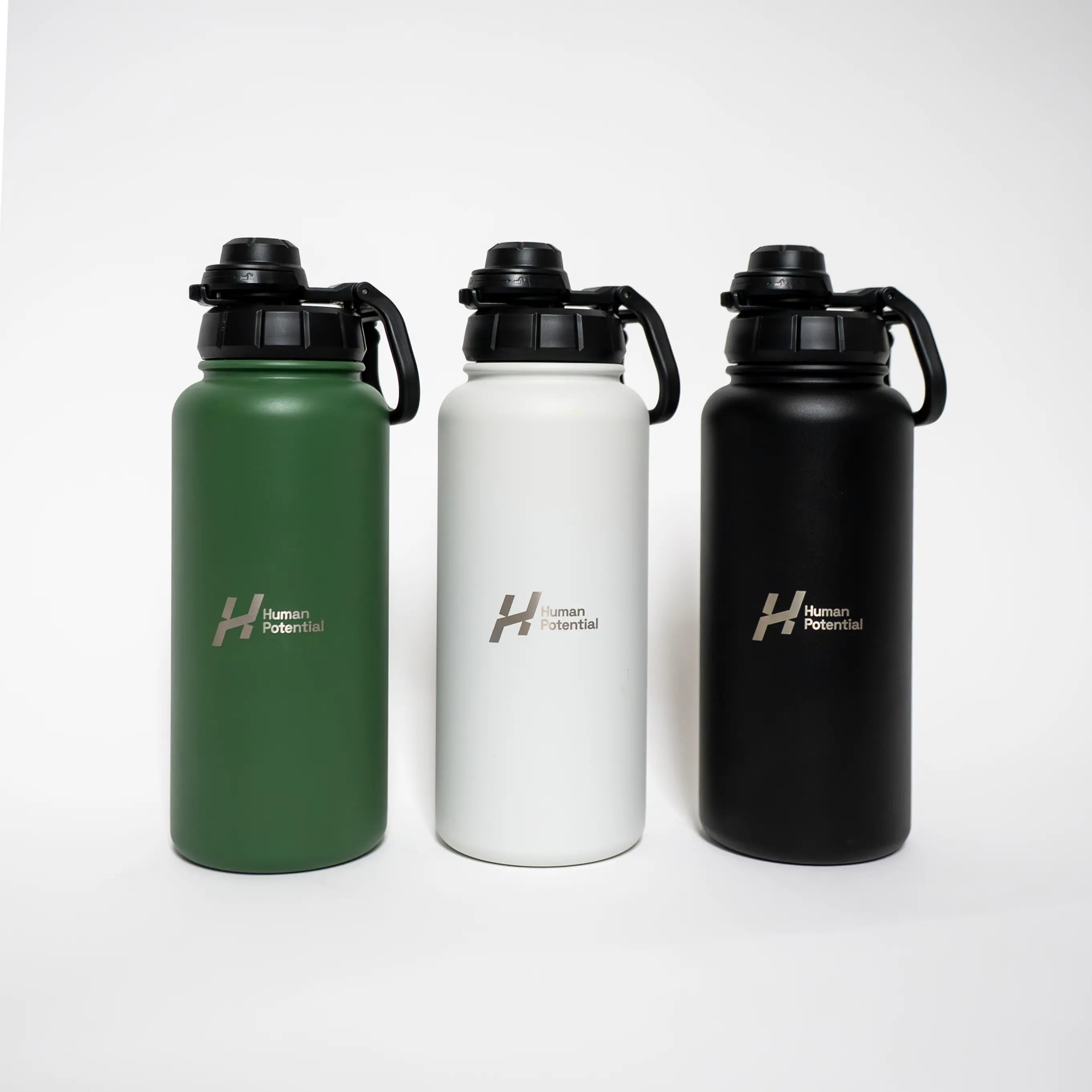 Three water bottles in green, white, and black with 'Human Potential' logo on a white background